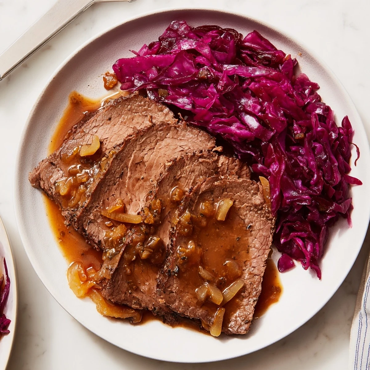 Herzhafter Sauerbraten, perfekt für Familientreffen, serviert mit süßem Rotkohl.  