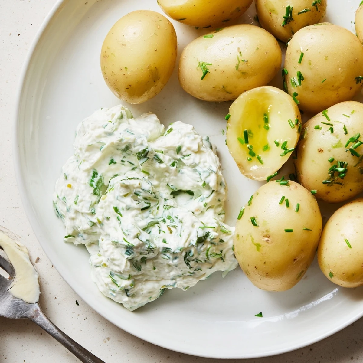 Zarte neue Kartoffeln, serviert mit herzhaftem Quark-Dip voller frischer Kräuter.  