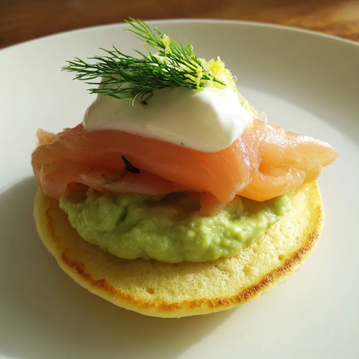 Quark Blinis topped with smoked salmon and vibrant avocado cream, ready to serve as an appetizer.