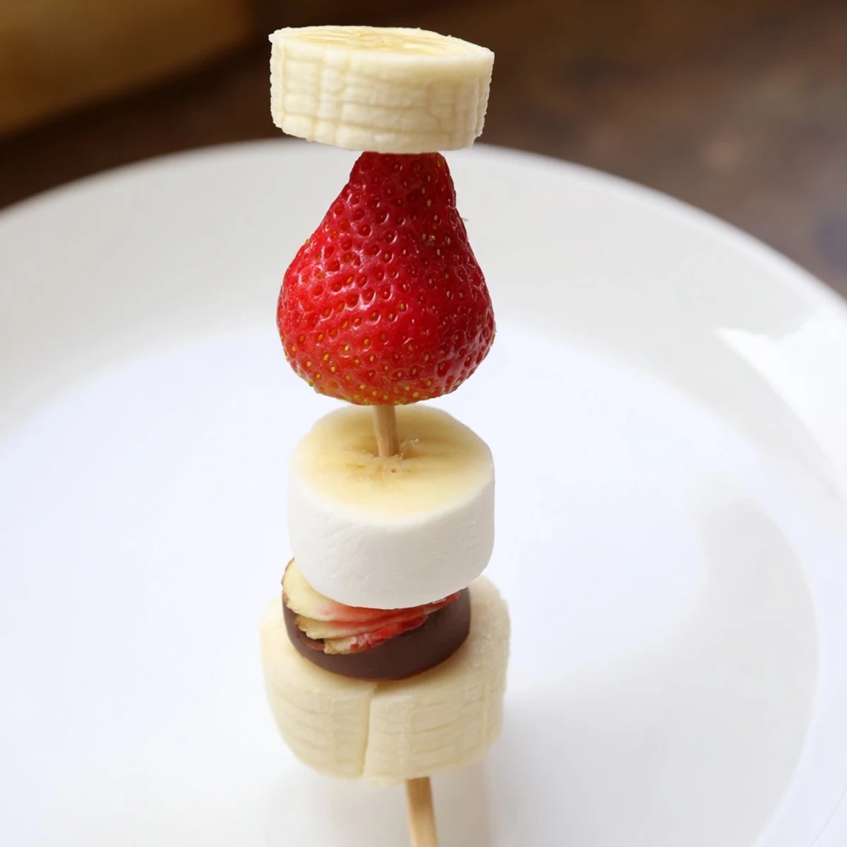 Köstliche Erdbeer-Bananen-Santa-Sticks, die aussehen wie kleine Weihnachtsmann-Hüte, perfekt für Kinder.