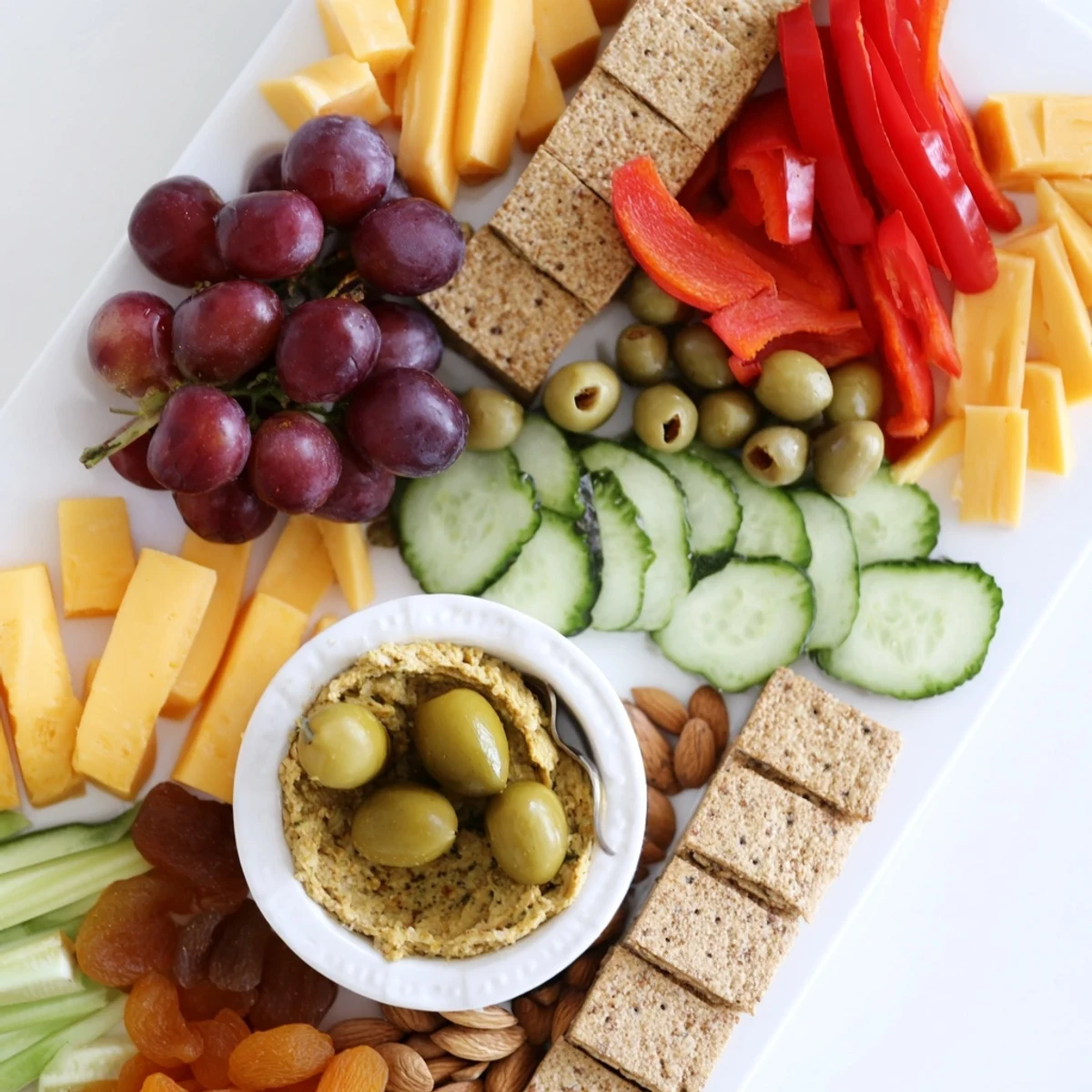 Perfect party appetizer: vibrant arrowhead charcuterie board with pointed grapes, cheese, and salami.