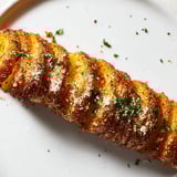 Close-up of perfectly roasted Tornado Potatoes, with vibrant herbs, ready to be enjoyed.