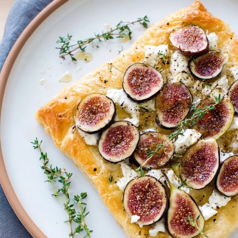 Golden, crispy puff pastry truffle pizza, topped with figs and goat cheese, ready to serve, appetizer.