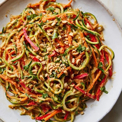 Spiralized zucchini and colorful veggies mingle with a rich peanut sauce in these Zesty Peanut Zucchini Noodles.