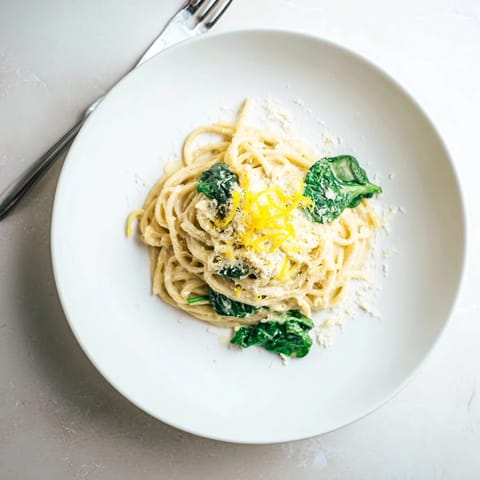 Cremige Zitrone Spinat Spaghetti dampfend im Topf mit glatter Sauce, Baby Spinat und Knoblauch für den Abend.