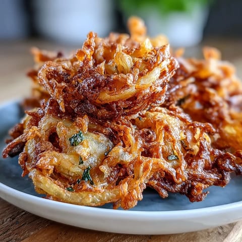 Luftgebackene Zwiebel-Bhajis mit frischem Koriander und grünen Chilis, perfekt als veganer, glutenfreier Vorspeise.  