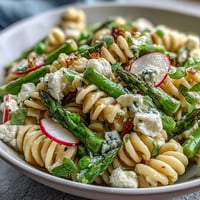 Frischer Nudelsalat mit knackigen Radieschen und Zitronenvinaigrette in heller Schüssel.